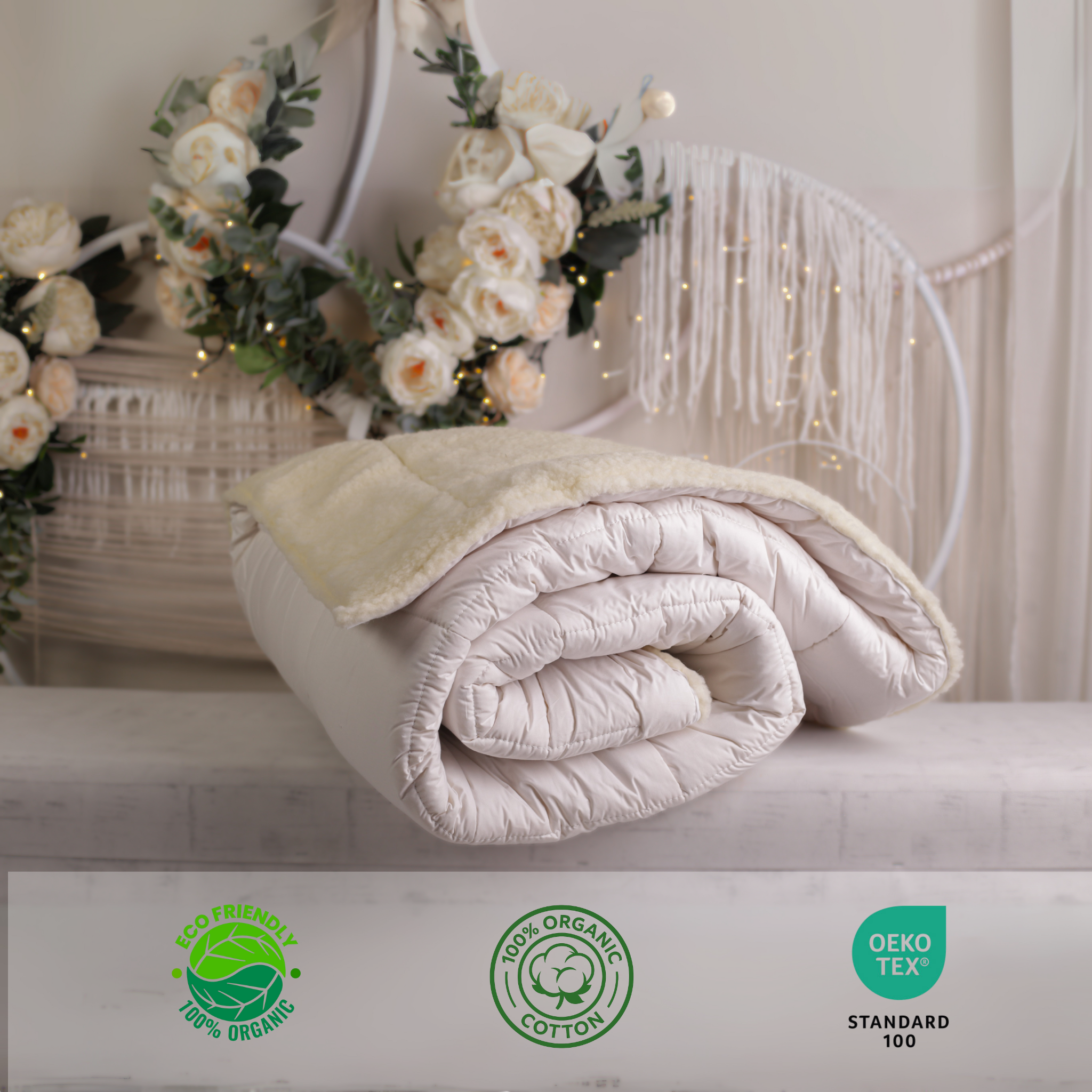 Die Schurwolle Bettdecke Gold Lux auf einer schönen Ablage. Die Decke ist eingerollt und zeigt seine natürliche Elastizität. Im unteren Teil befinden sich Bio-Siegel und das Siegel OEKO TEX Standard 100, was zeigt, dass alle Materialien nachhaltig, sicher und ohne Chemikalien sind.