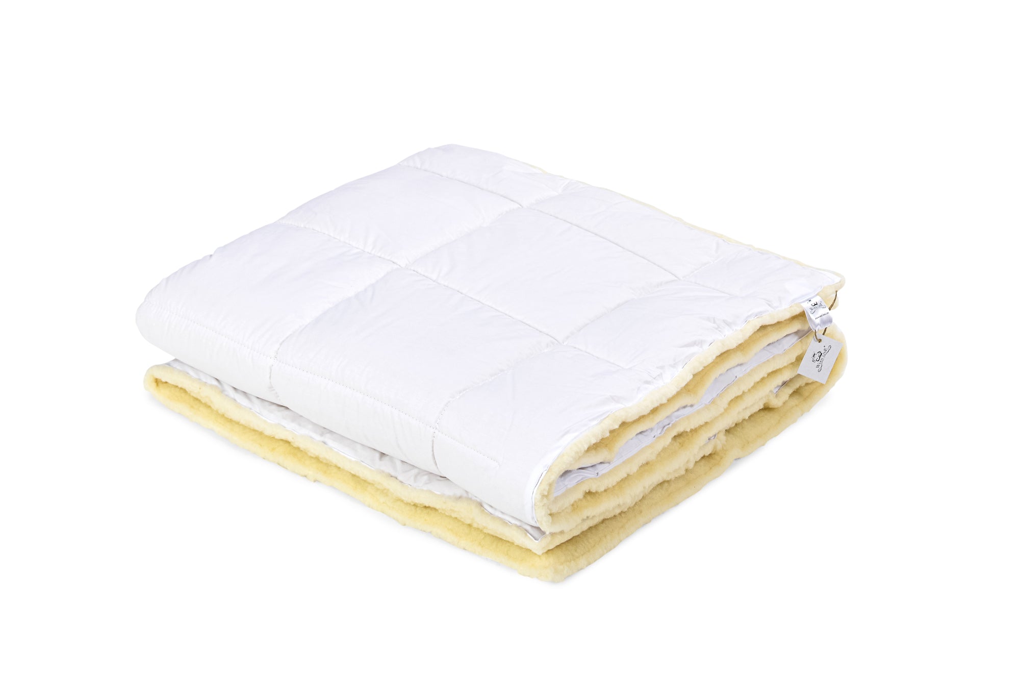 Die Ganzjahres-Bettdecke Gold Lux von Wool-Line als Modell. Die Bettdecke ist eingeklappt und zeigt in der Oberseite den feinen Baumwollbezug für den Sommer, während die andere Seite aus Wollfilz im Winter angenehm wärmt.