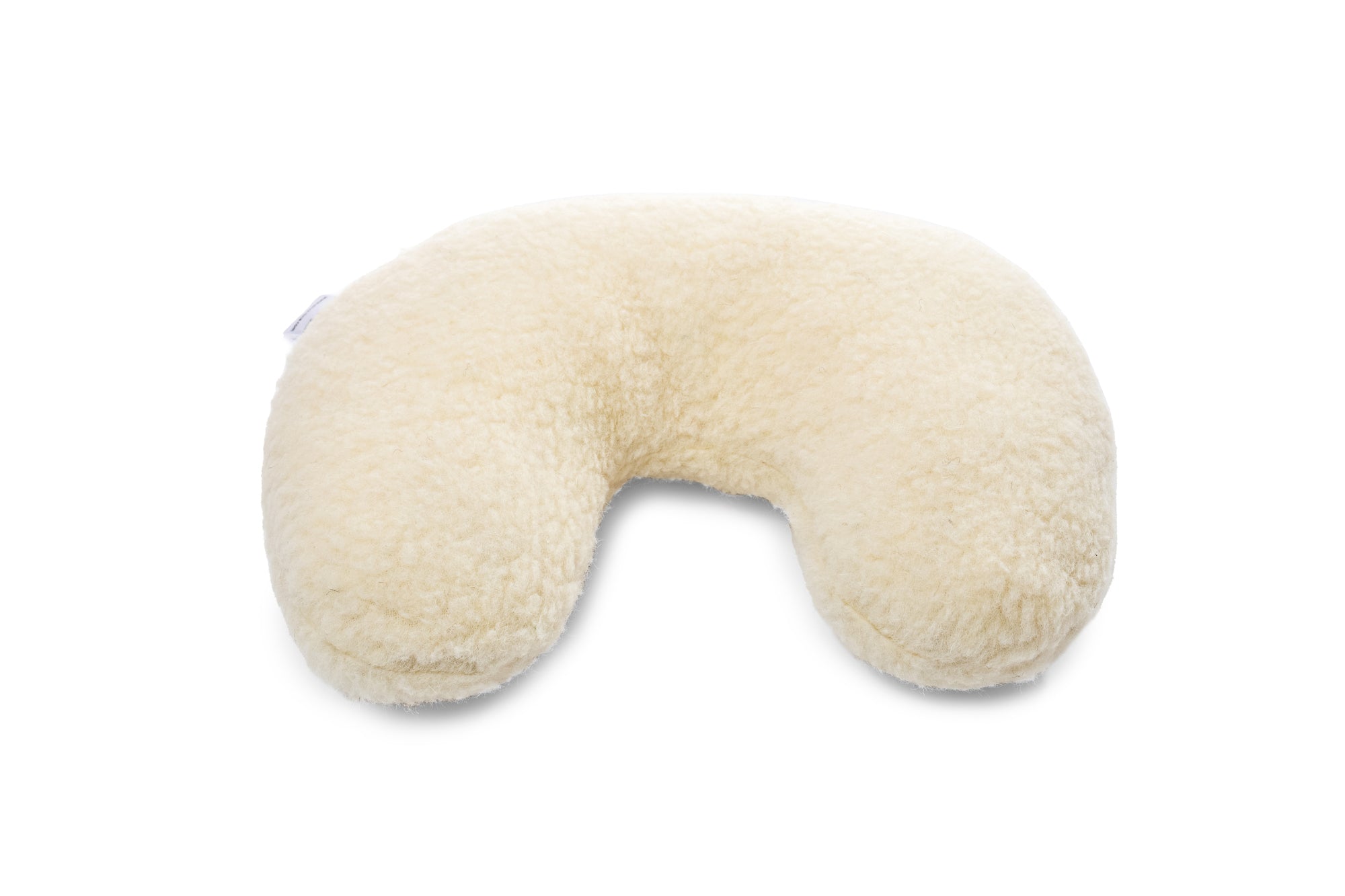 Unser Nackenstützkissen für die Reise ausgestellt auf weißem Untergrund. Die feinen Filzkonturen aus Schafschurwolle sind gut und detailliert im Licht zu sehen.