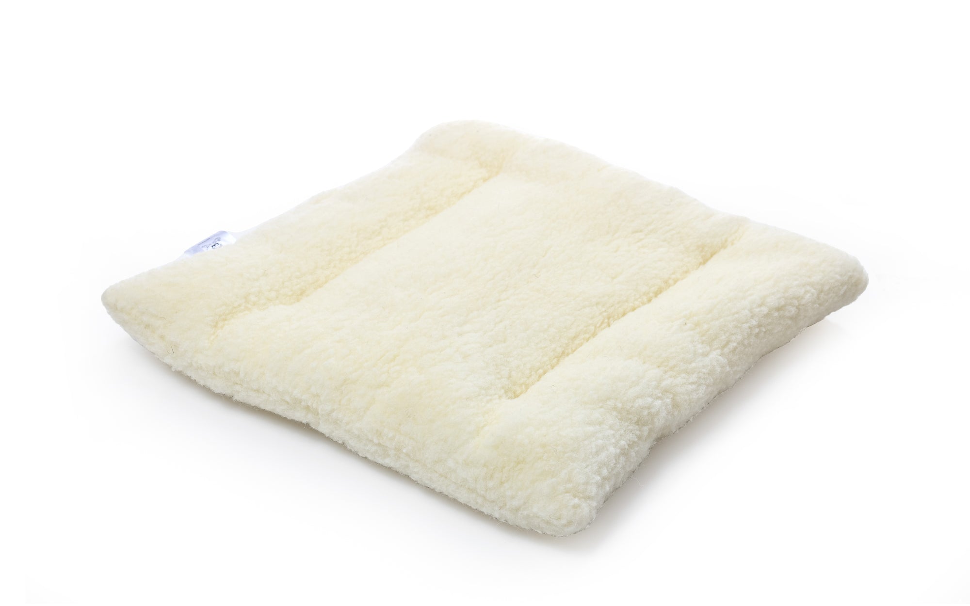 Die Wool-Line Stuhlauflage aus Filz auf weißem Untergrund. Die beige Stuhlauflage ist mit hochwertigem Filz bezogen. Im Inneren befindet sich das Futter aus kleinen Schafschurwoll-Kügelchen.