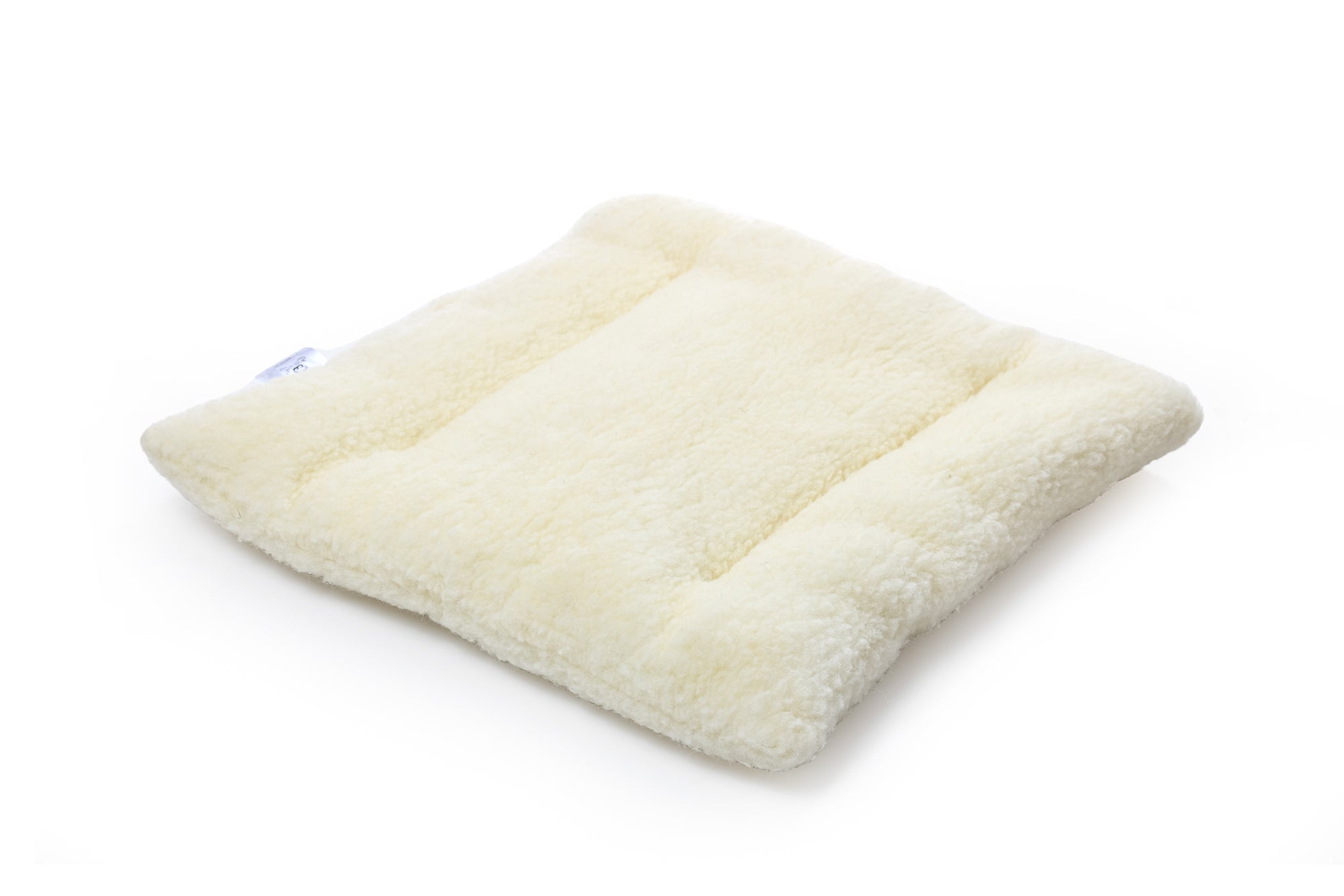 Die Wool-Line Stuhlauflage aus Filz auf weißem Untergrund. Die beige Stuhlauflage ist mit hochwertigem Filz bezogen. Im Inneren befindet sich das Futter aus kleinen Schafschurwoll-Kügelchen.