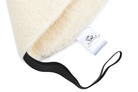 Die warme Sitzauflage von Wool-Line in der Nahaufnahme. Darauf sind die feinen Konturen des warmen Filz aus Schafschurwolle sowie ein schwarzer Befestigungsgurt klar zu erkennen. Der Fokus liegt auf einem kleinen Zettel an der Außenseite der Sitzauflage für das Auto, auf dem das Wool-Line Logo abgebildet ist.