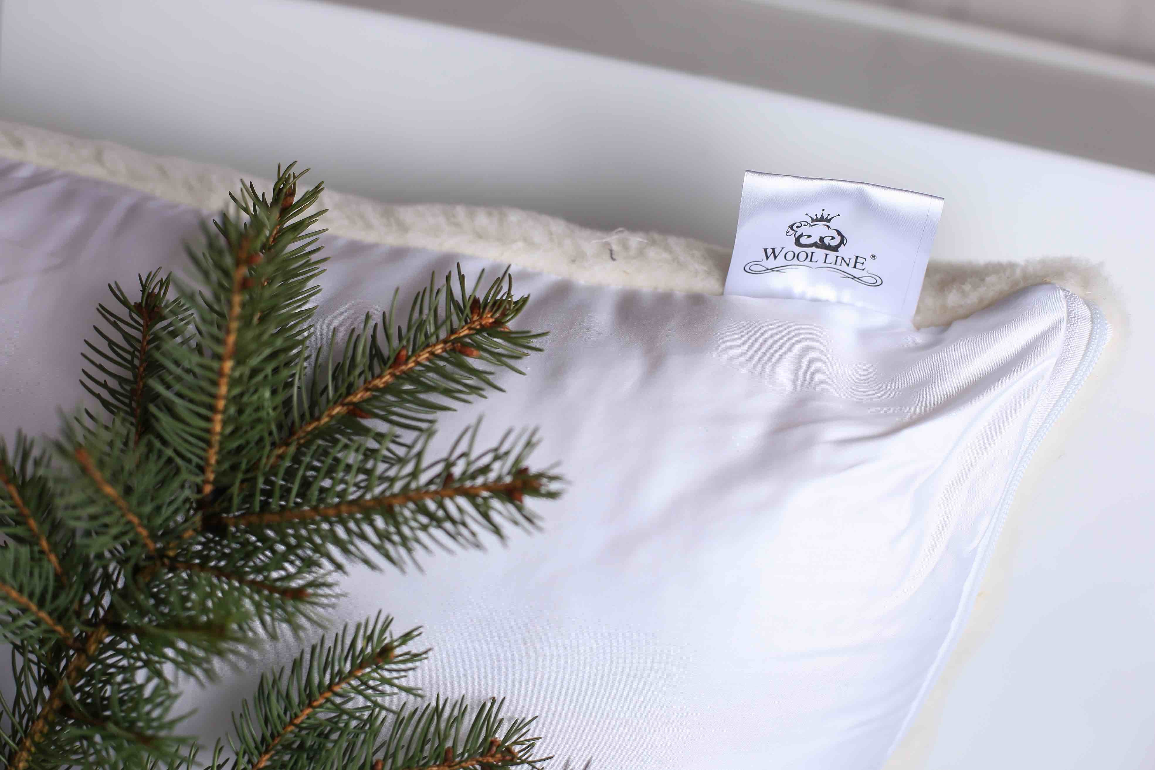 Das Wool-Line Kissen aus Schafwolle Gold/Lux in der Nahaufnahme. Oben rechts ist deutlich ein kleiner angepinnter Zettel zu sehen, auf dem das Wool-Line Logo zu sehen ist.