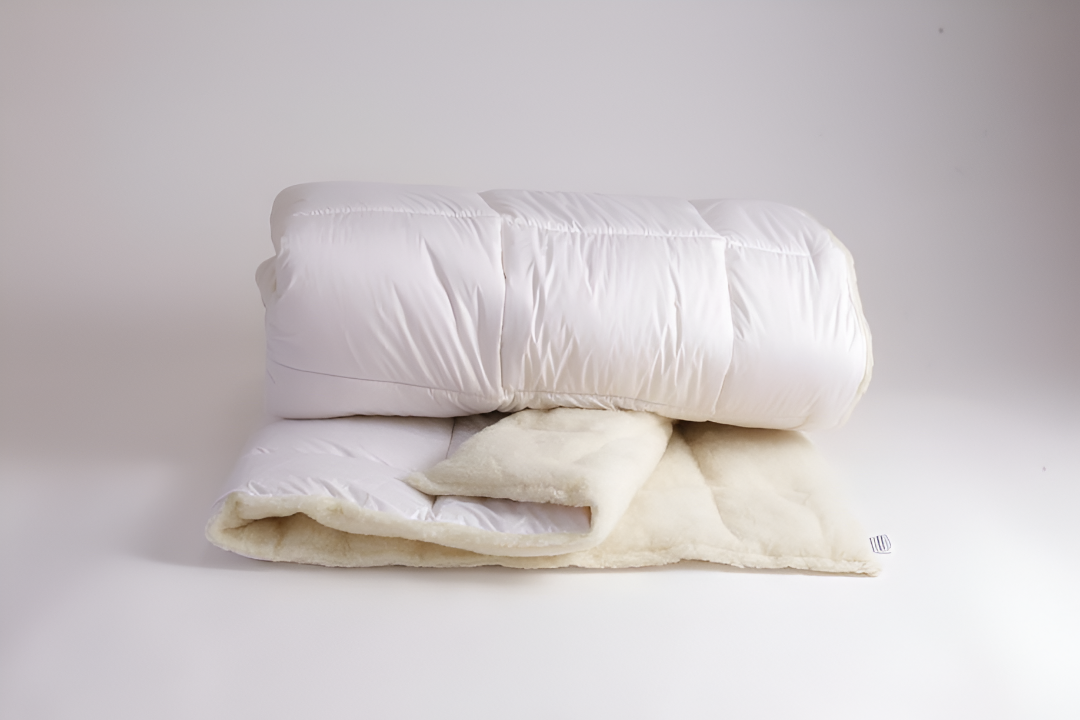 Die gefaltete Bettdecke Schurwolle Gold Lux als Modell. 