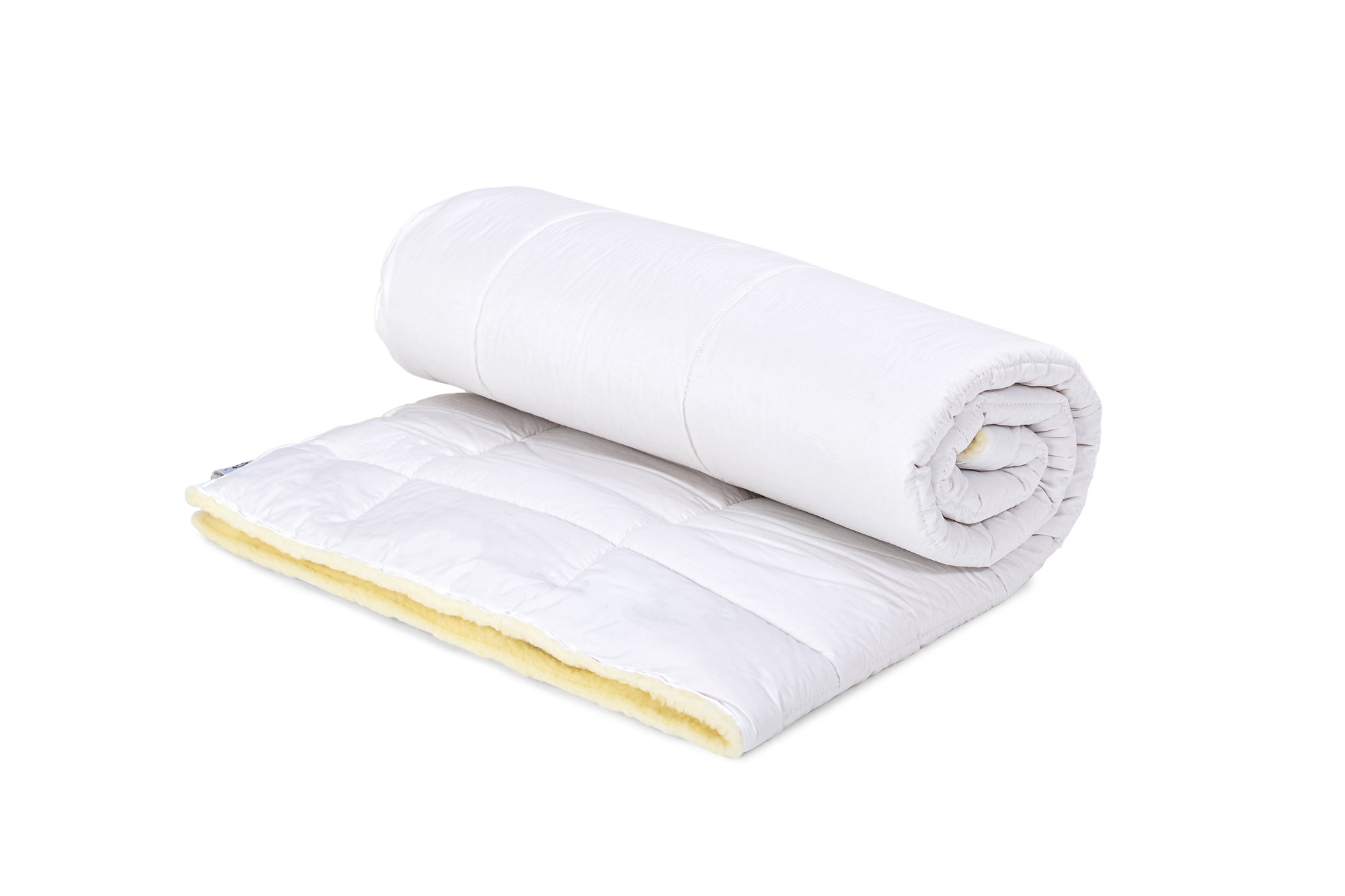 Die Bettdecke aus Schurwolle von Wool-Line ist ganzjährig zum Schlafen benutzbar. Auf dem Bild befindet sich ein eingerolltes Modell. 