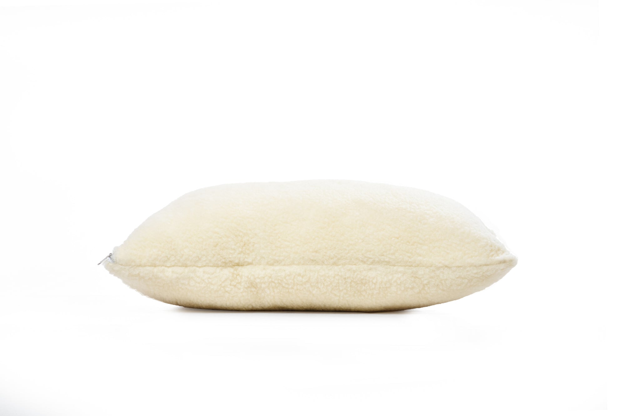 Das Wool-Line Kissen Schafschurwolle Gold auf weißem Untergrund mit mittelgroßer Füllmenge. Die Füllmenge an Schafschurwolle ist flexibel anpassbar je nach Schlafgewohnheit. 