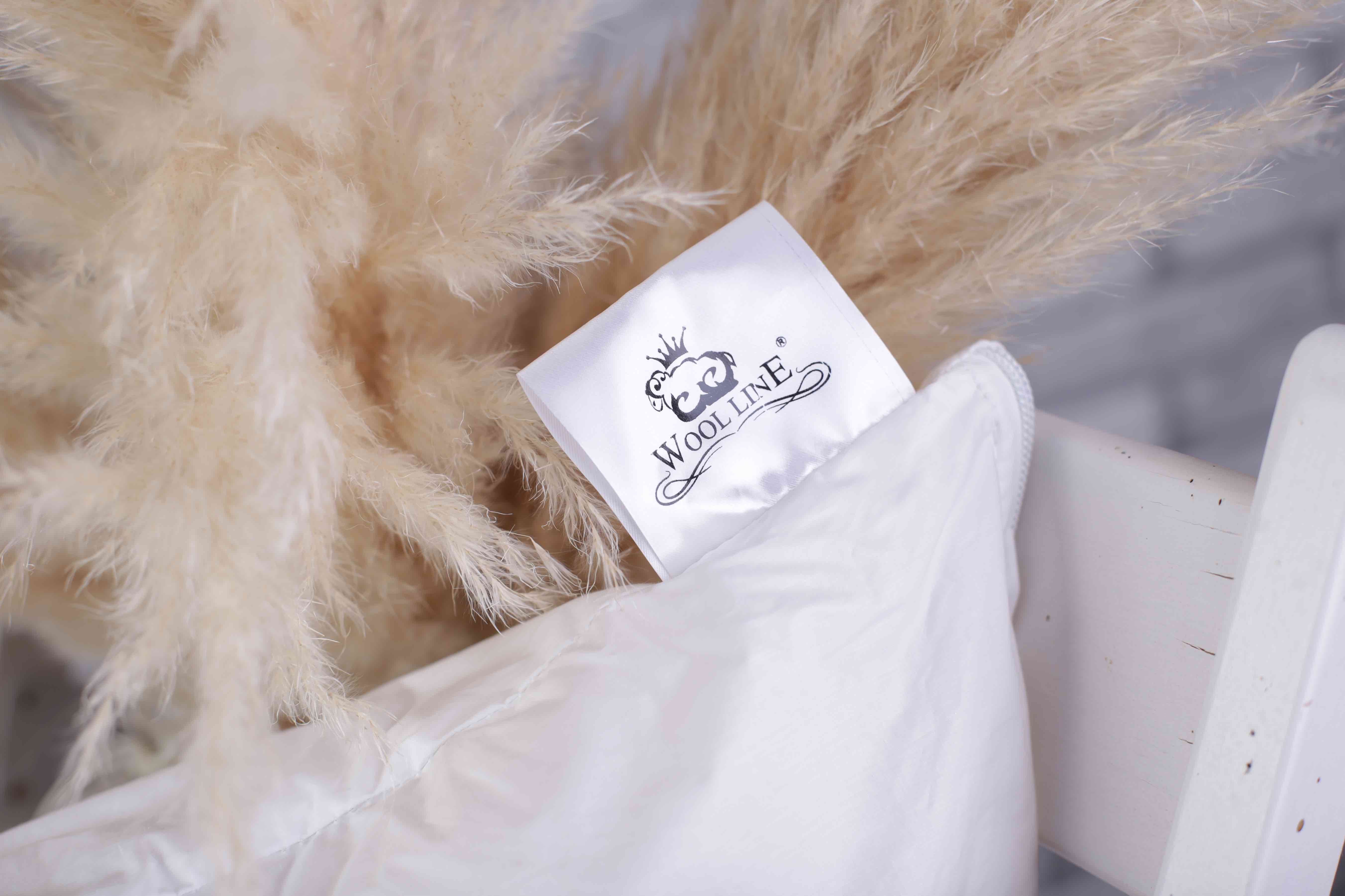 Eine Nahaufnahme des kleinen Zettel an der Seite des Schurwolle Kissen  Lux. Darauf befindet sich das Wool-Line Logo. 