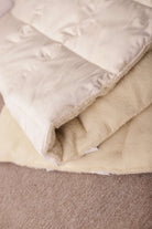 Der Topper Natur Bio von Wool-Line auf dem Untergrund. In der Nahaufnahme ist der weiche Filzbezug aus reiner Schafschurwolle zu sehen. 